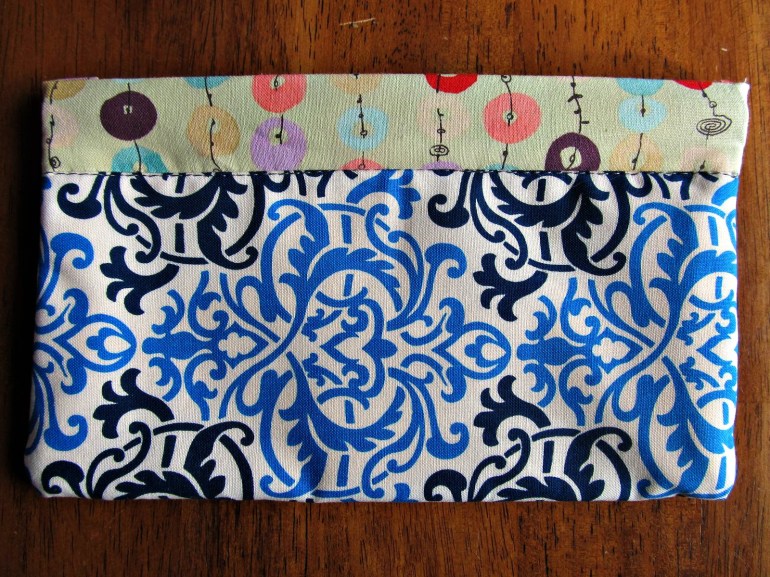 A simple sewn pouch for toting little goodies around in. It measures about 4.5 by 8 inches.